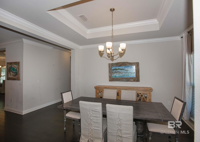 dining space featuring an inviting chandelier, a raised ceiling, wood finished floors, visible vents, and ornamental molding