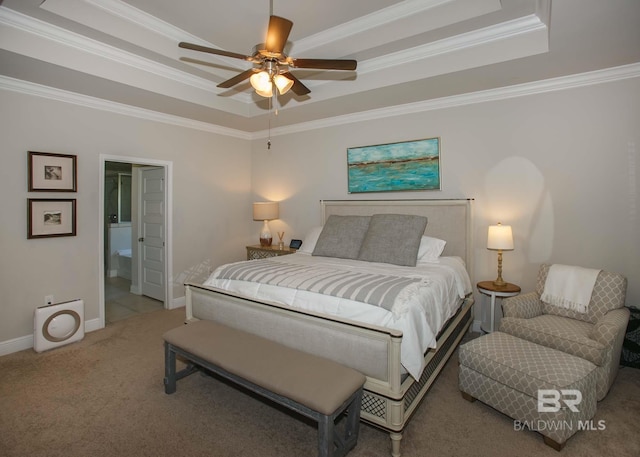 bedroom with ornamental molding, carpet, and a tray ceiling