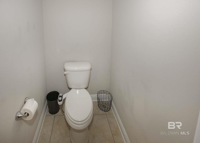 bathroom featuring baseboards, tile patterned floors, and toilet