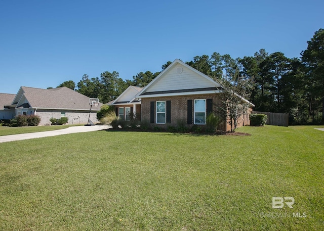 view of front facade with brick siding, fence, and a front yard