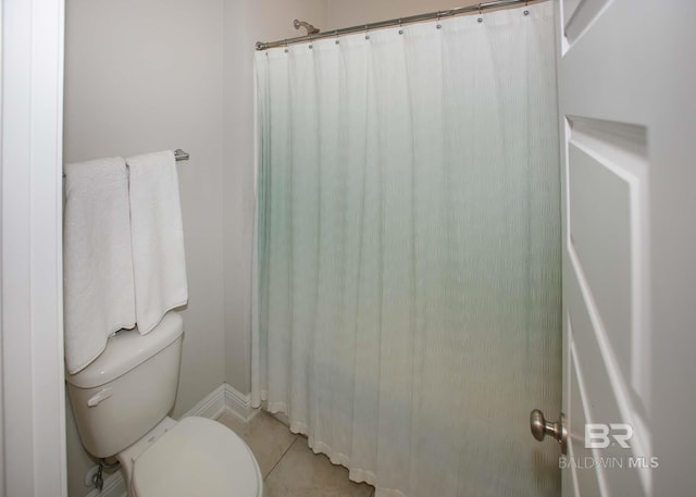 full bath with toilet, baseboards, and tile patterned flooring
