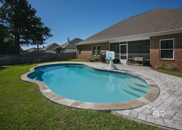 view of pool with a sunroom, a fenced backyard, a fenced in pool, a patio, and a yard