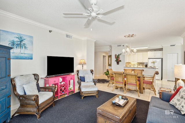 living room with light tile patterned floors, ceiling fan with notable chandelier, visible vents, and ornamental molding