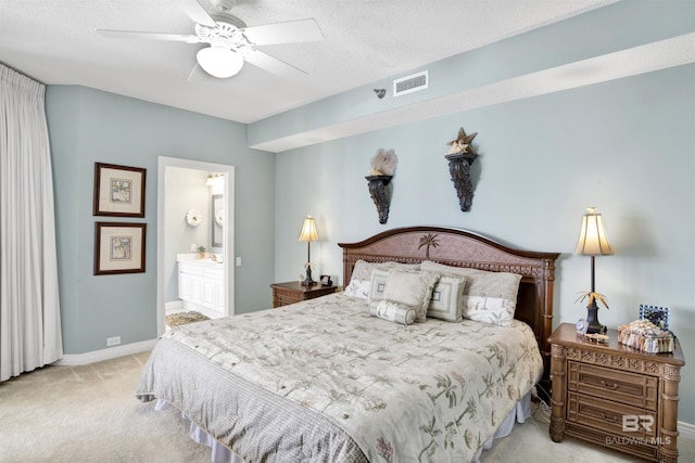 carpeted bedroom with visible vents, ceiling fan, a textured ceiling, ensuite bath, and baseboards