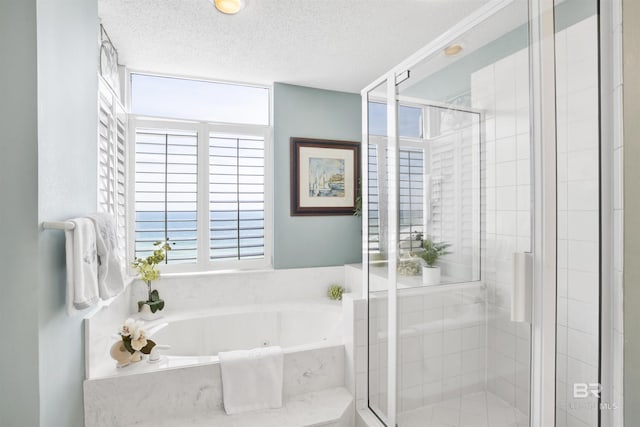 bathroom featuring plenty of natural light, a textured ceiling, a bath, and a shower stall