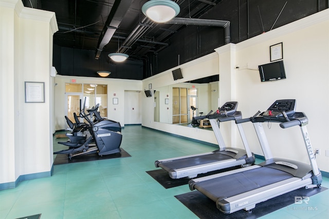 workout area featuring a towering ceiling and baseboards