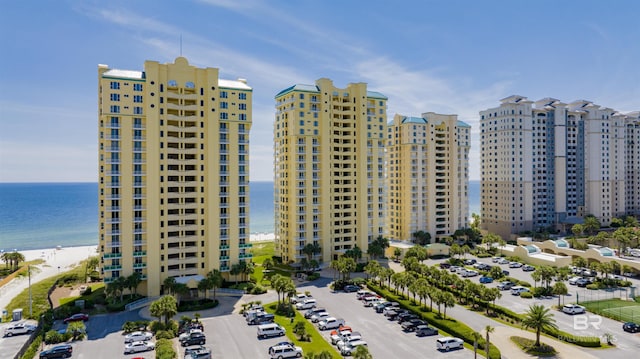 view of property featuring uncovered parking, a view of city, and a water view