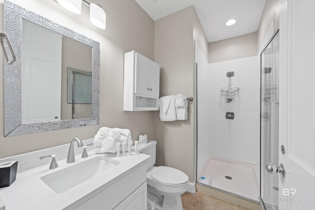 bathroom featuring vanity, tile patterned floors, toilet, and a stall shower