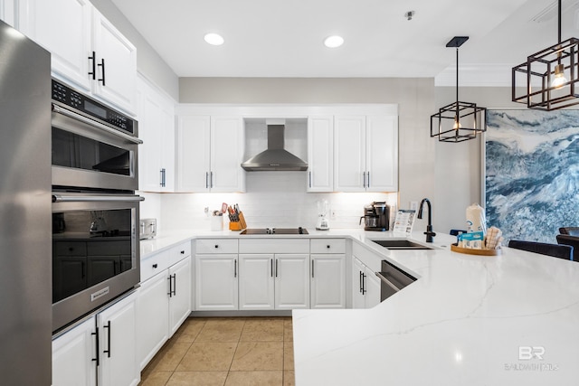 kitchen with a sink, tasteful backsplash, appliances with stainless steel finishes, wall chimney exhaust hood, and white cabinets