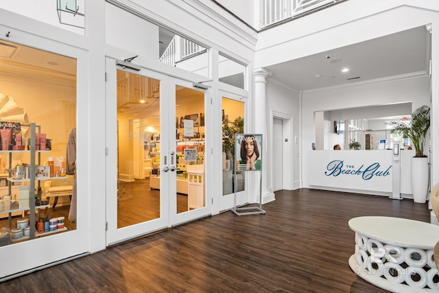 interior space featuring dark wood finished floors, crown molding, and a towering ceiling