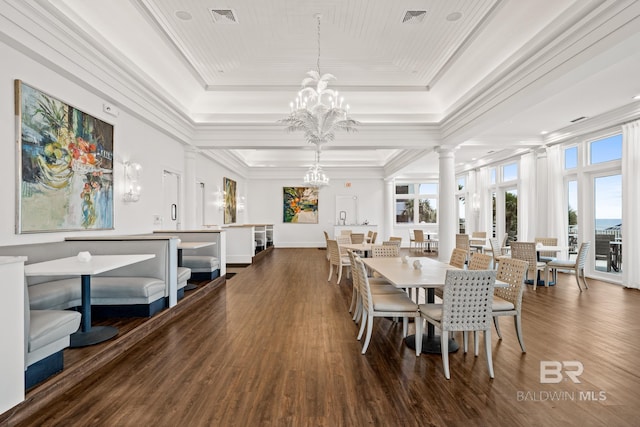 dining area with a raised ceiling, a notable chandelier, visible vents, and decorative columns