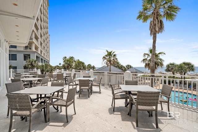 view of patio with a community pool and outdoor dining space