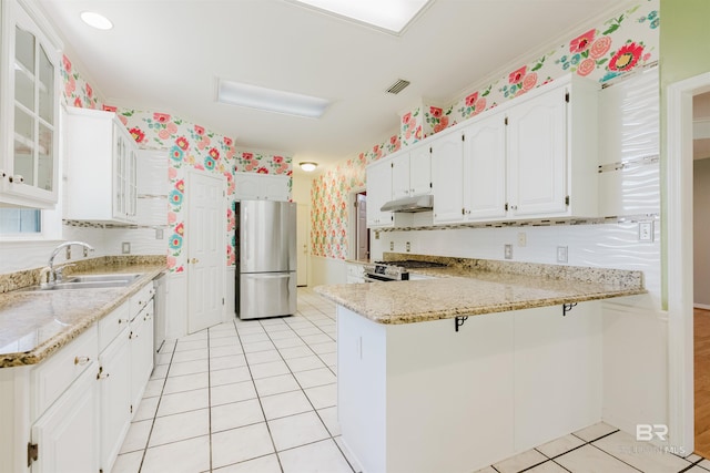 19711 Hunters Loop, Fairhope, AL 36532 - kitchen with stainless steel appliances, a sink, under cabinet range hood, a peninsula, and wallpapered walls