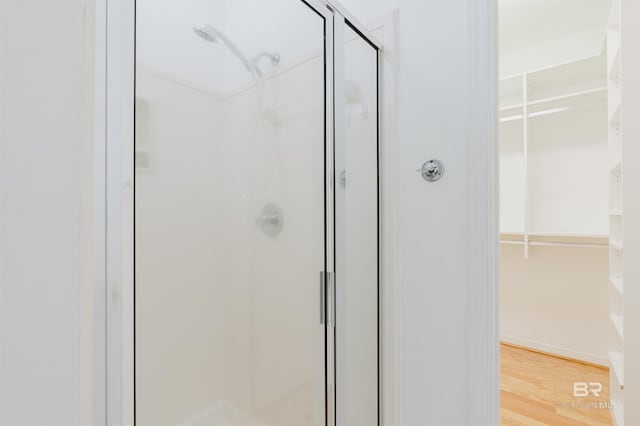 19711 Hunters Loop, Fairhope, AL 36532 - bathroom featuring a shower stall, a walk in closet, and wood finished floors