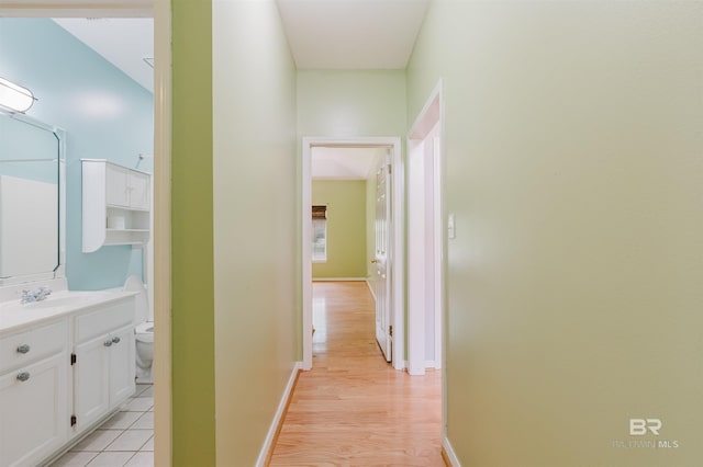 19711 Hunters Loop, Fairhope, AL 36532 - hallway with baseboards, light wood-style flooring, and a sink