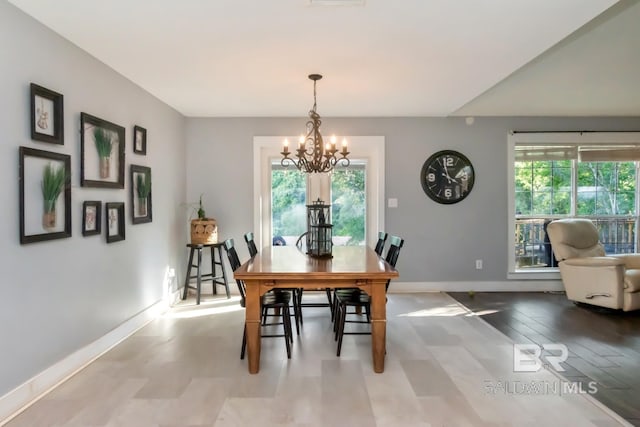 dining space featuring a chandelier, plenty of natural light, and baseboards