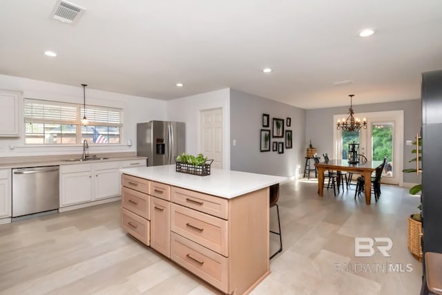 kitchen featuring a sink, appliances with stainless steel finishes, a chandelier, visible vents, and light countertops