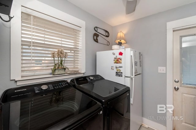 laundry area featuring washing machine and clothes dryer, laundry area, and baseboards
