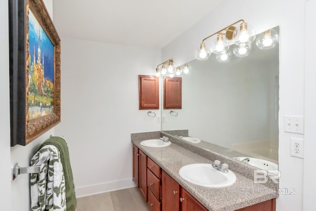 bathroom with double vanity, a sink, and baseboards