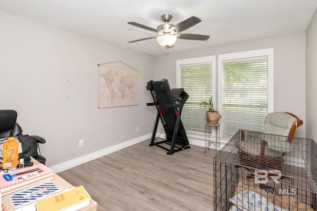 interior space with baseboards, light wood-type flooring, and ceiling fan
