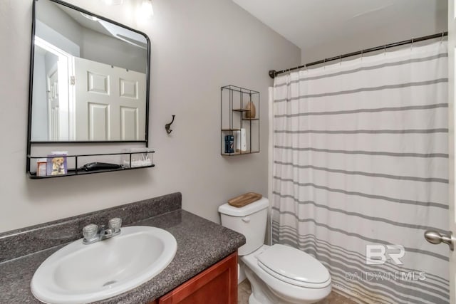 bathroom featuring toilet, vanity, and a shower with shower curtain