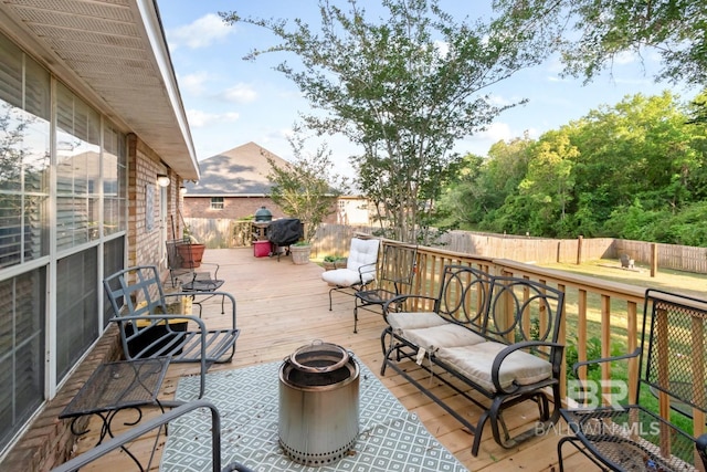 wooden terrace with area for grilling and a fenced backyard