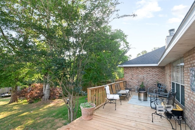 wooden deck featuring a lawn