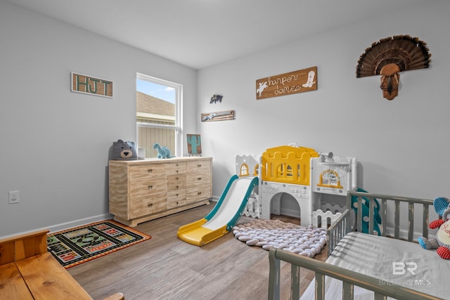 bedroom featuring a crib and hardwood / wood-style flooring