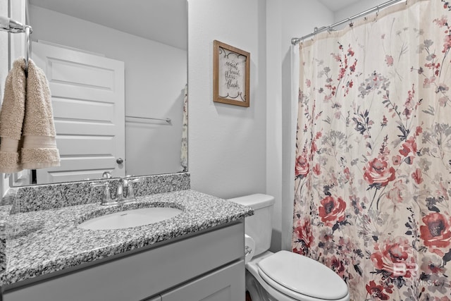 bathroom with a shower with shower curtain, vanity, and toilet