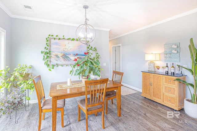 dining area with dark hardwood / wood-style floors, an inviting chandelier, and crown molding