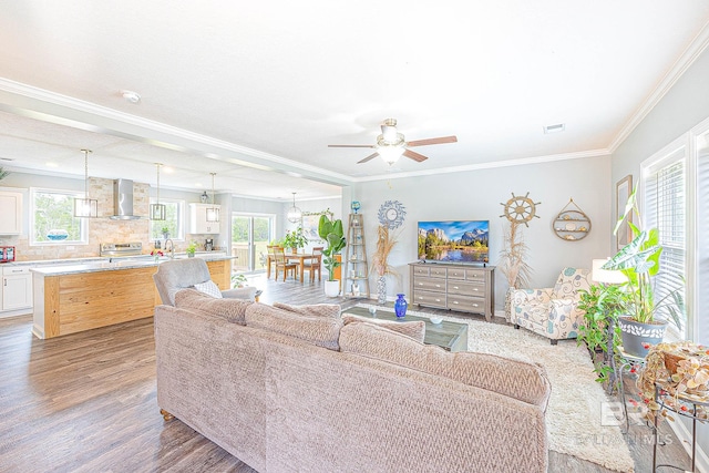 living room featuring ceiling fan, hardwood / wood-style flooring, and ornamental molding