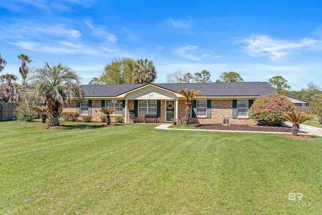 ranch-style house with a front yard, fence, and brick siding