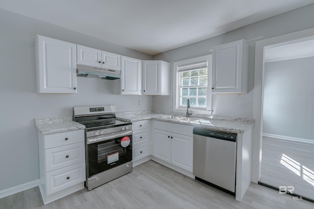 kitchen featuring sink, appliances with stainless steel finishes, white cabinetry, light stone countertops, and light wood-type flooring