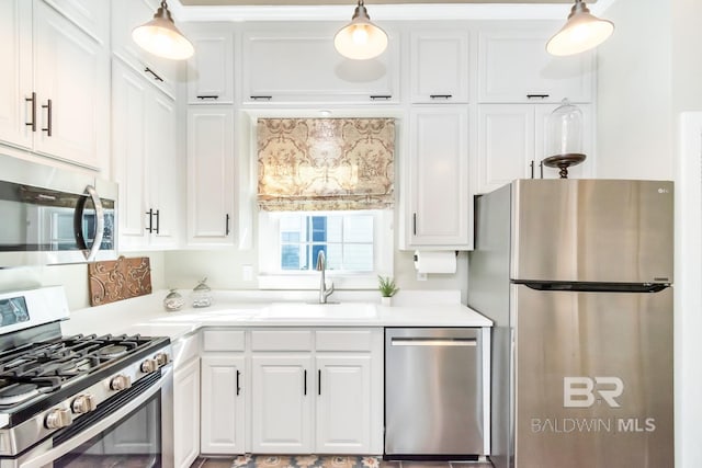 kitchen with white cabinetry, sink, pendant lighting, and appliances with stainless steel finishes