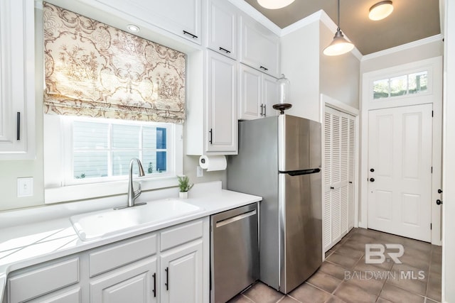 kitchen with hanging light fixtures, sink, white cabinets, and stainless steel appliances