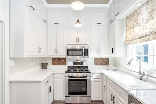 kitchen with white cabinetry, sink, decorative light fixtures, and appliances with stainless steel finishes