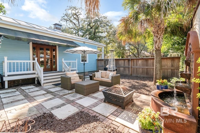 view of patio / terrace featuring french doors and an outdoor living space with a fire pit