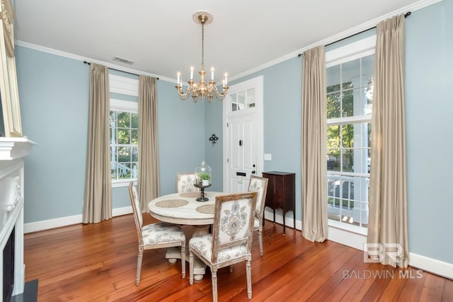 dining area featuring a chandelier, wood-type flooring, and crown molding