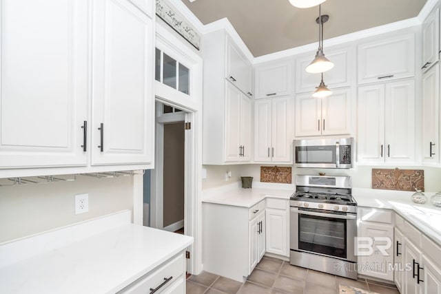 kitchen featuring light tile patterned floors, white cabinets, decorative light fixtures, and appliances with stainless steel finishes