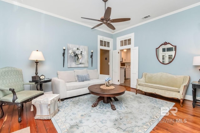 living room with ceiling fan, wood-type flooring, and crown molding