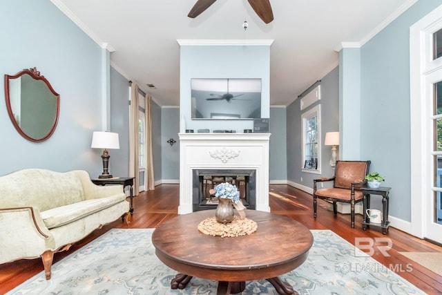 sitting room with dark wood-type flooring and crown molding