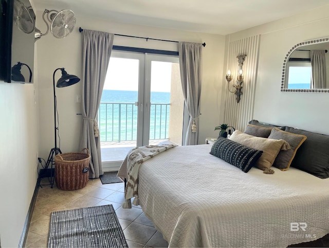 bedroom with light tile patterned floors, a water view, and access to exterior