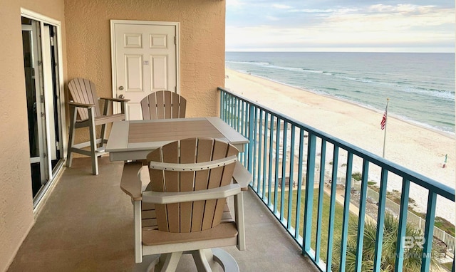 balcony featuring a view of the beach and a water view