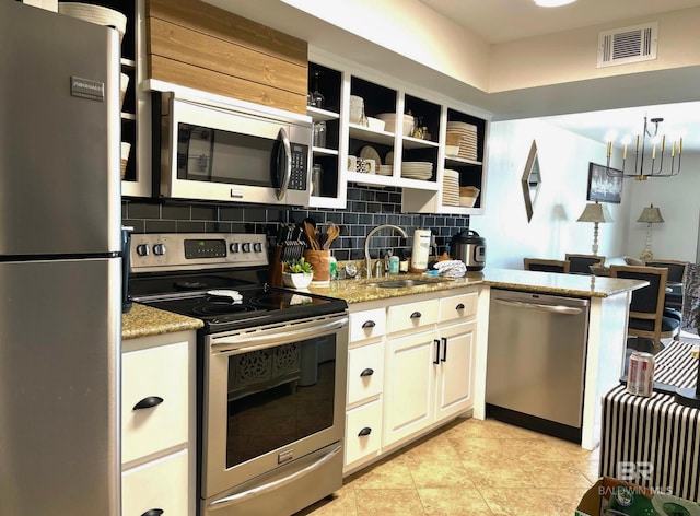 kitchen with stainless steel appliances, visible vents, backsplash, white cabinetry, and a sink