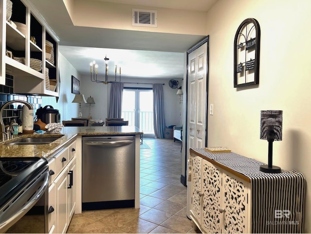 kitchen with visible vents, stainless steel dishwasher, white cabinetry, a sink, and dark stone countertops