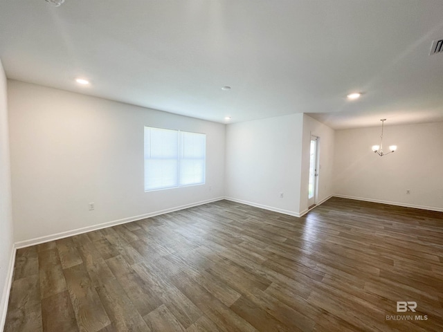 unfurnished room with dark hardwood / wood-style floors and a notable chandelier