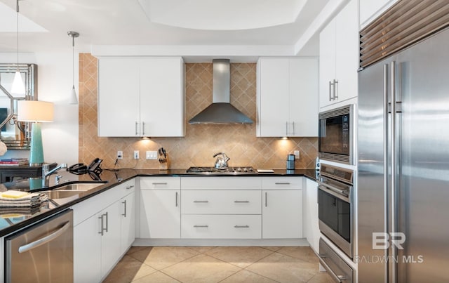 26302 Perdido Beach Blvd Unit D708, Orange Beach, AL 36561 - kitchen featuring built in appliances, wall chimney range hood, decorative backsplash, a warming drawer, and hanging light fixtures