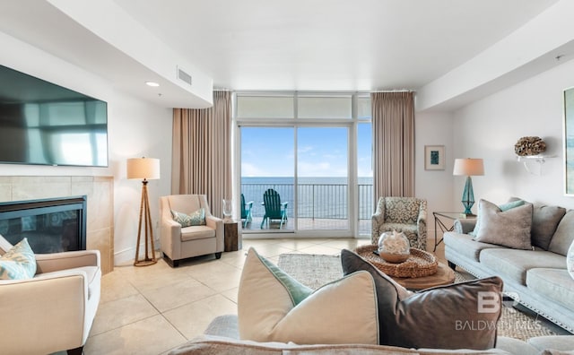 26302 Perdido Beach Blvd Unit D708, Orange Beach, AL 36561 - living room with tile patterned floors, a tile fireplace, a water view, and a wall of windows