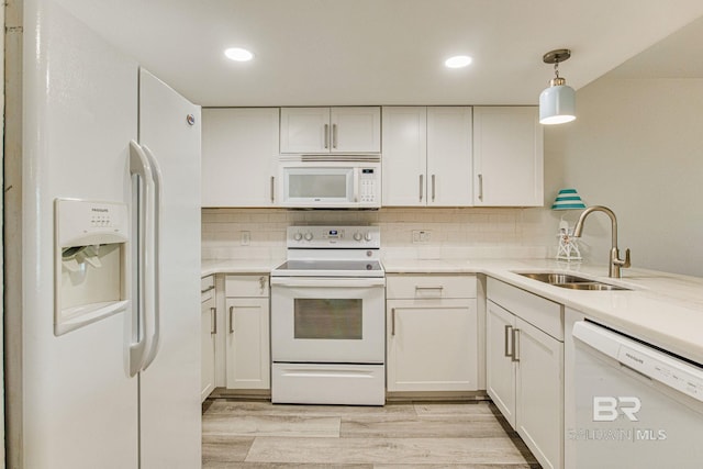 kitchen with sink, white appliances, white cabinetry, tasteful backsplash, and decorative light fixtures