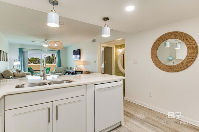 kitchen featuring white cabinetry, white dishwasher, hanging light fixtures, and light hardwood / wood-style flooring